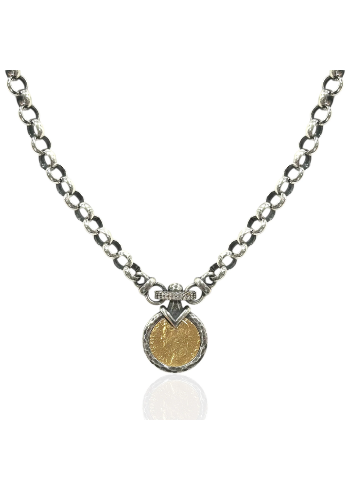 A vintage silver chain necklace with a gold coin pendant on a white background