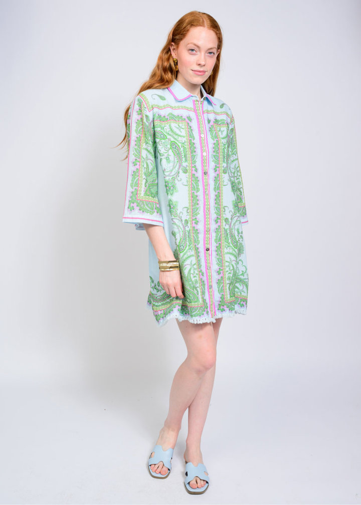 Woman wearing a blue, pink, and green button down collared mini dress