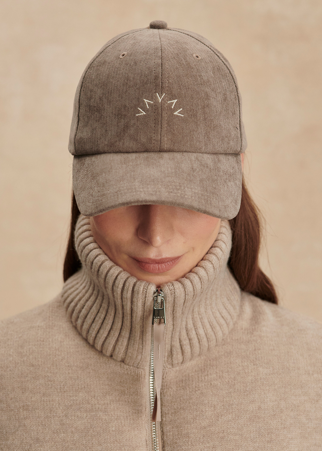 Woman wearing a brown hat with a "V" pattern