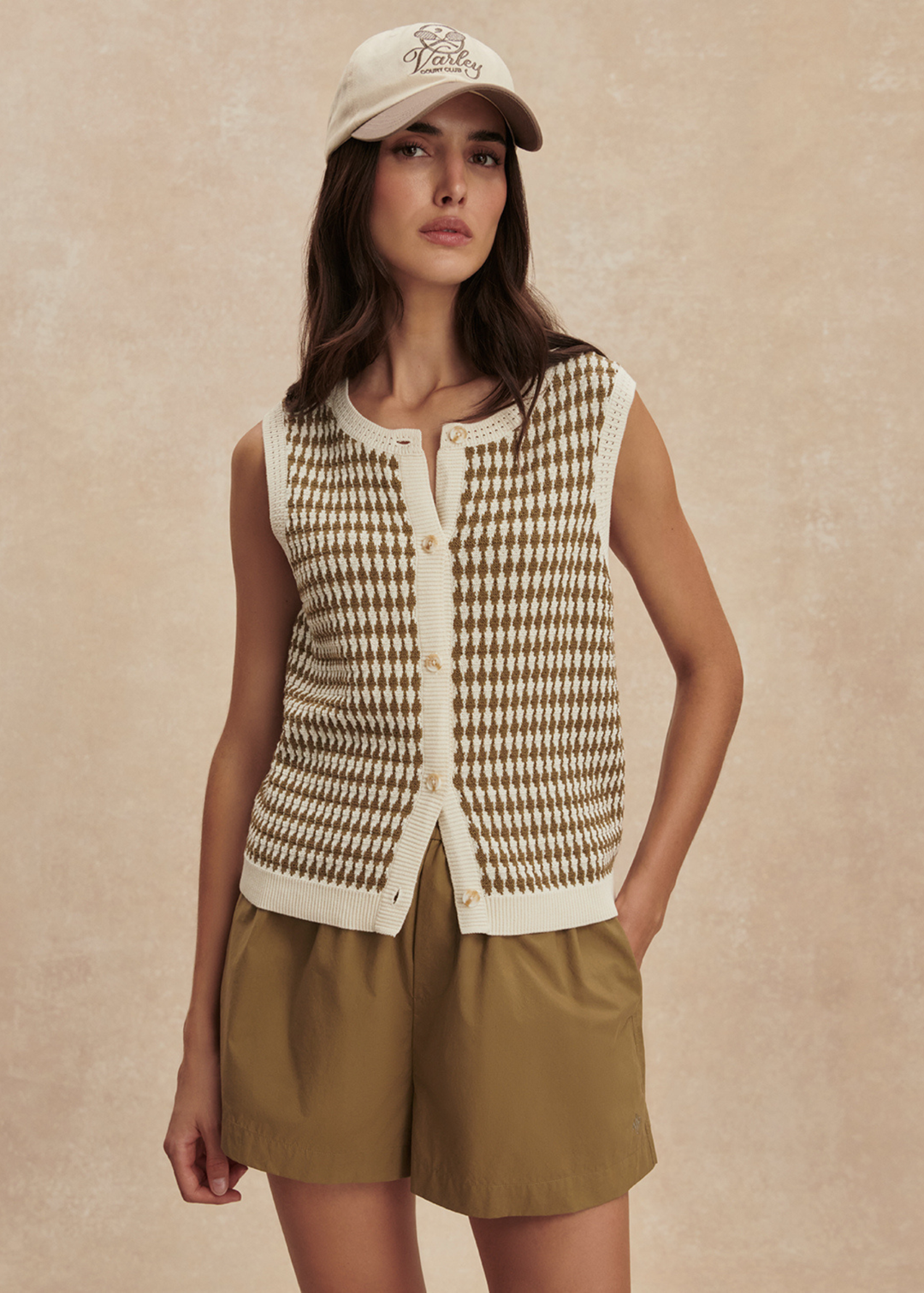 Woman wearing a gold and white knit tank with matching gold shorts