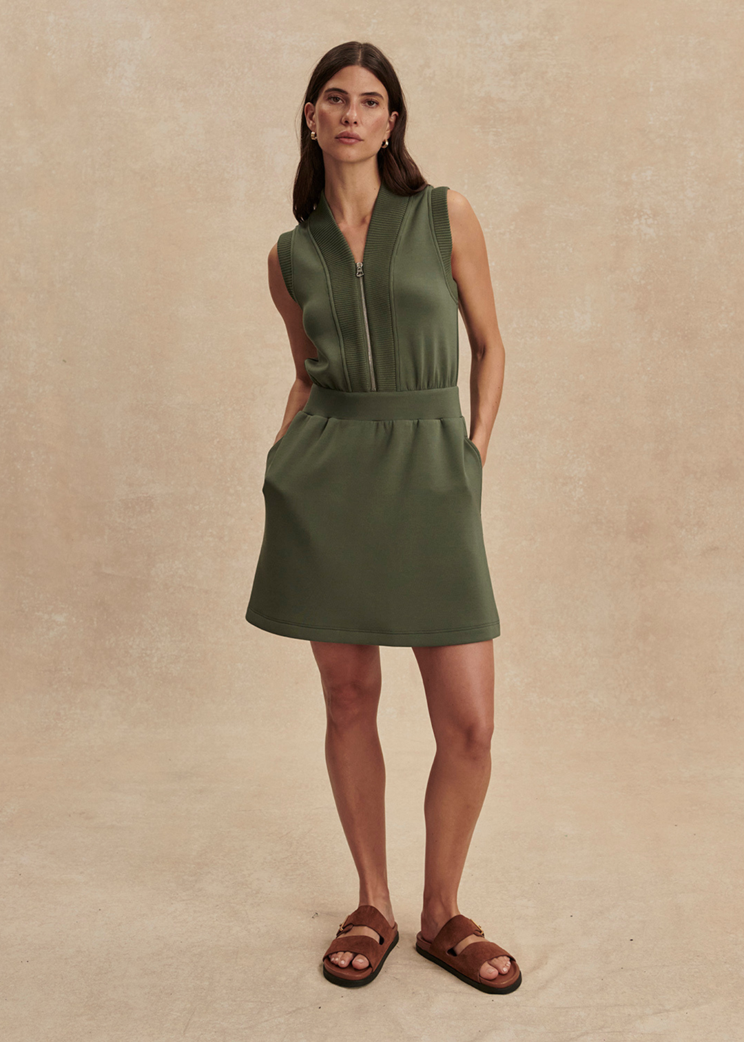 Woman wearing a green half zip mini dress with sandals
