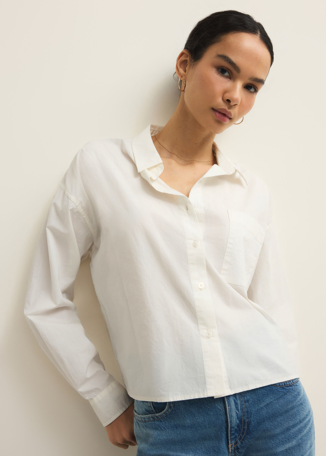 Woman wearing a white button down top with jeans