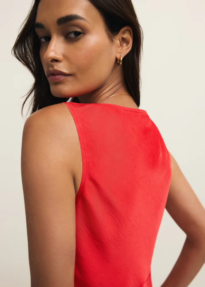Woman turned to the side wearing a red satin tank top