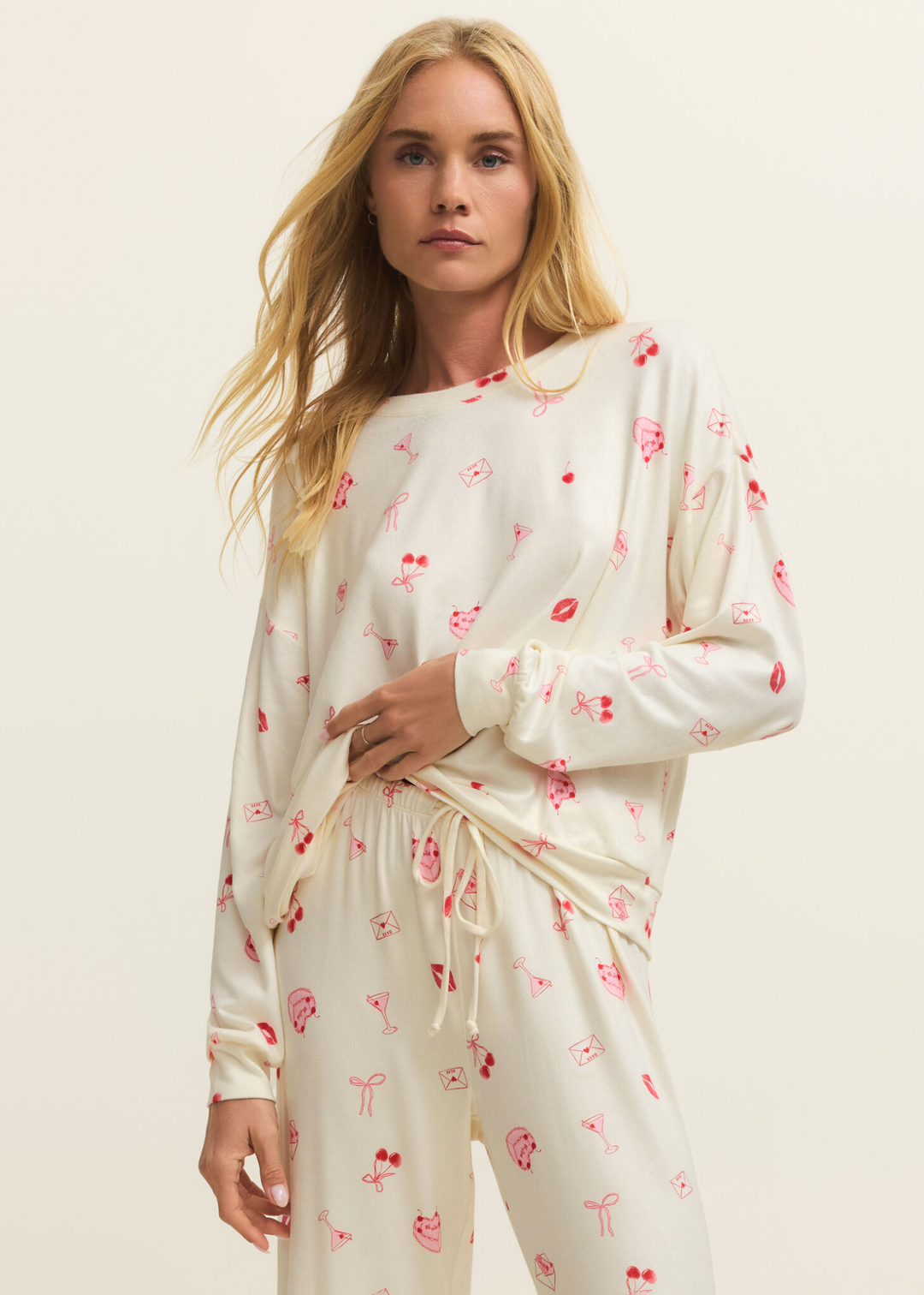 Woman wearing a white pj set with a pink and red graphic pattern