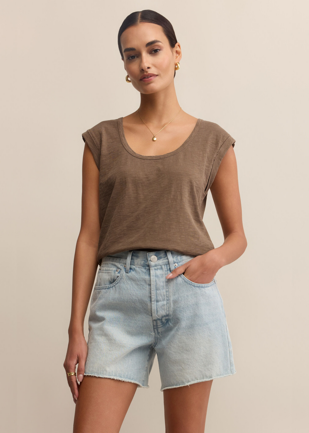 Woman wearing a brown sleeveless tee with a scoop neckline