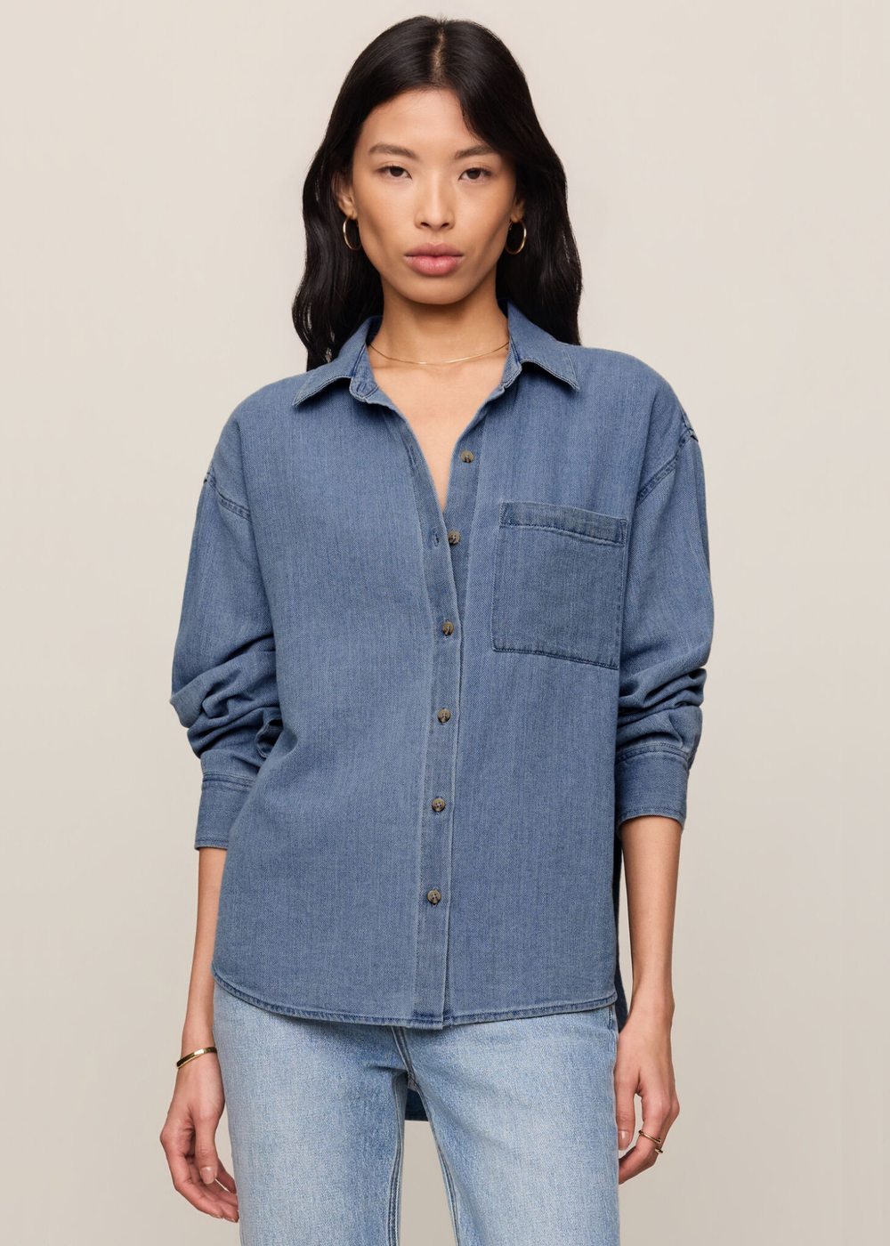 Woman wearing a denim button down top and jeans