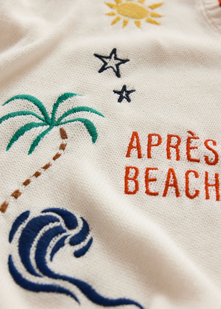 Close up of a white sweater with multicolor embroidery