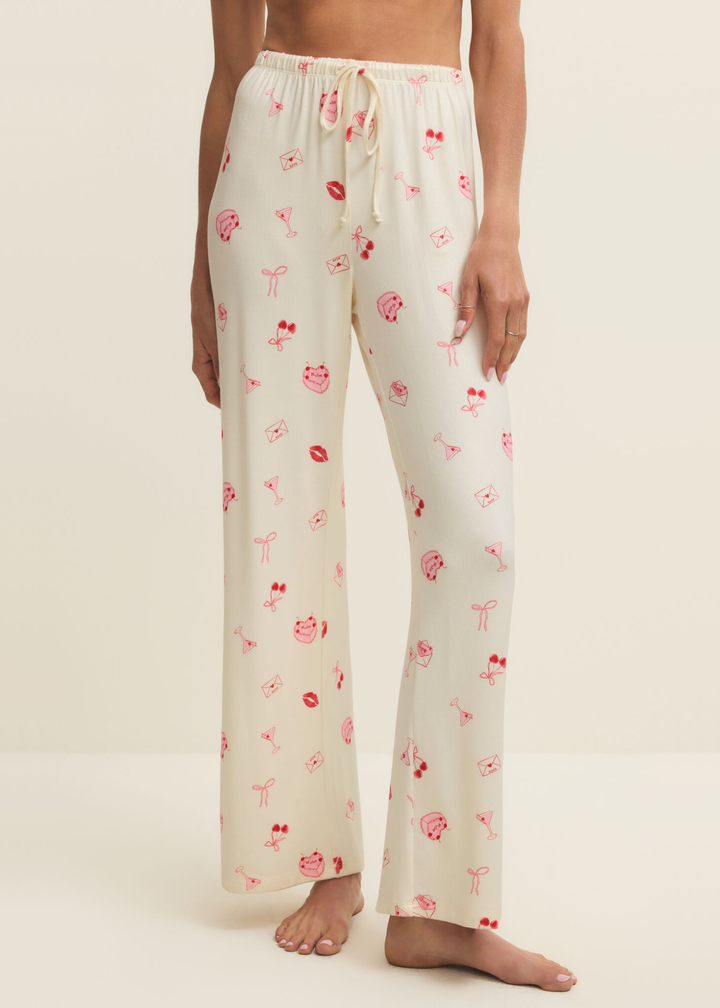 Woman wearing white pajama pants with a pink and red graphic pattern