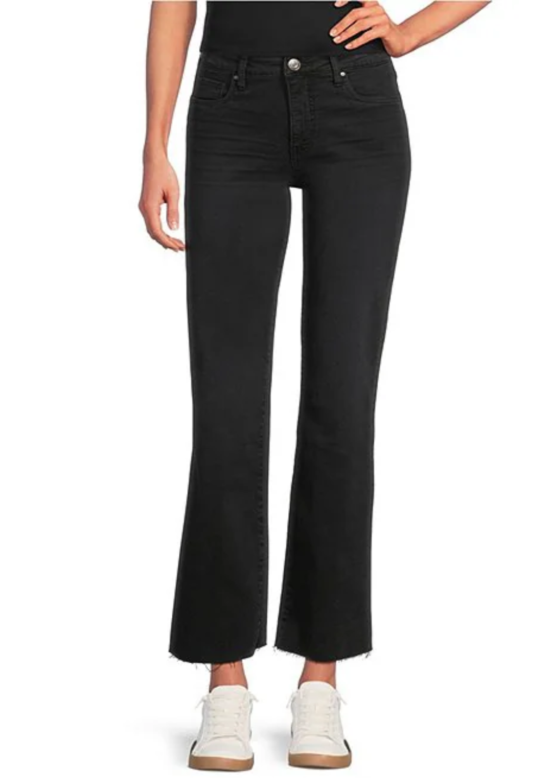A model wearing black cropped flare jeans with a raw hem and white sneakers, shown from the waist down on a white background.