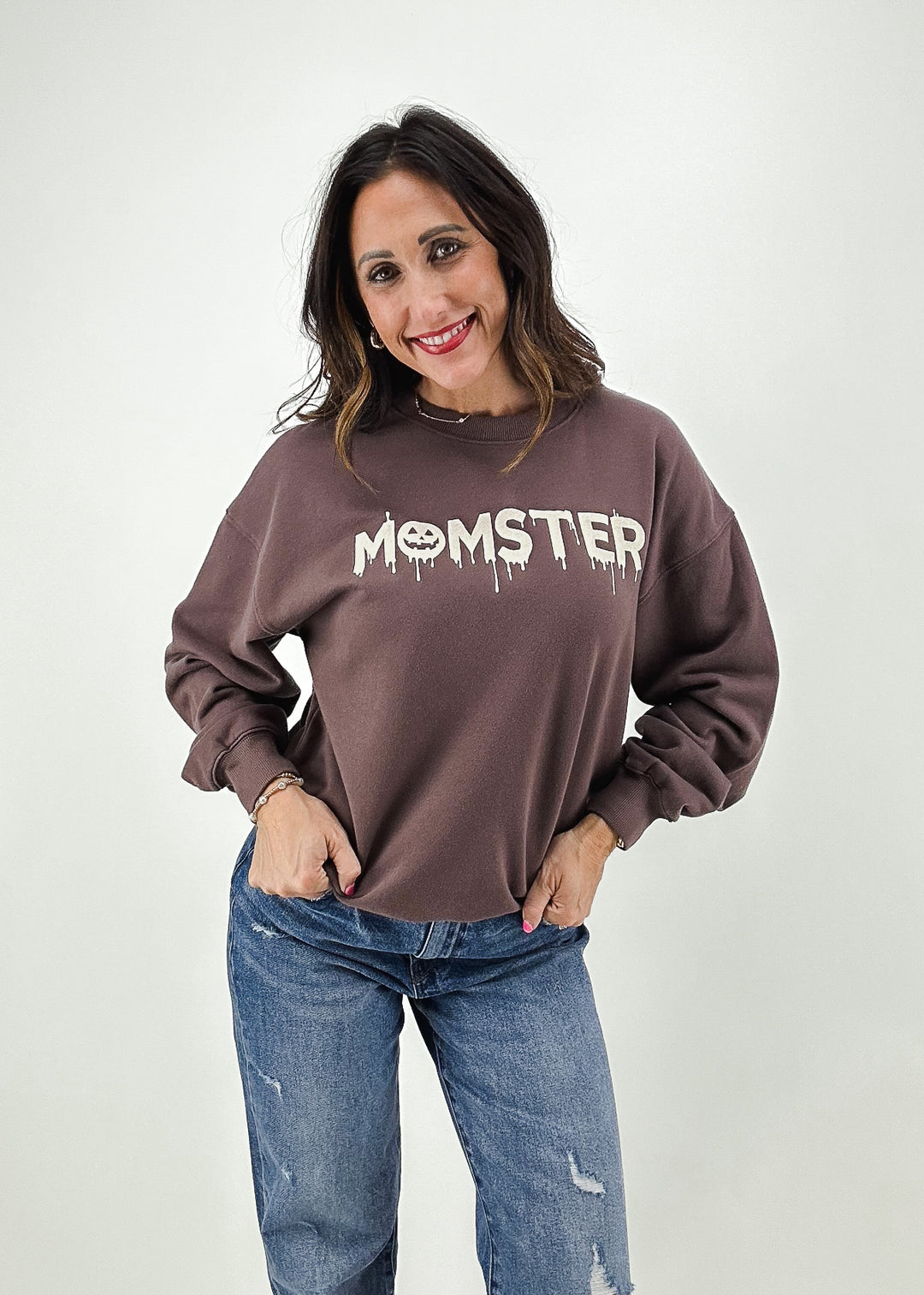 brown oversized crew neck with "momster" graphic on chest with spooky dripping letters and jack-o-lantern for the O