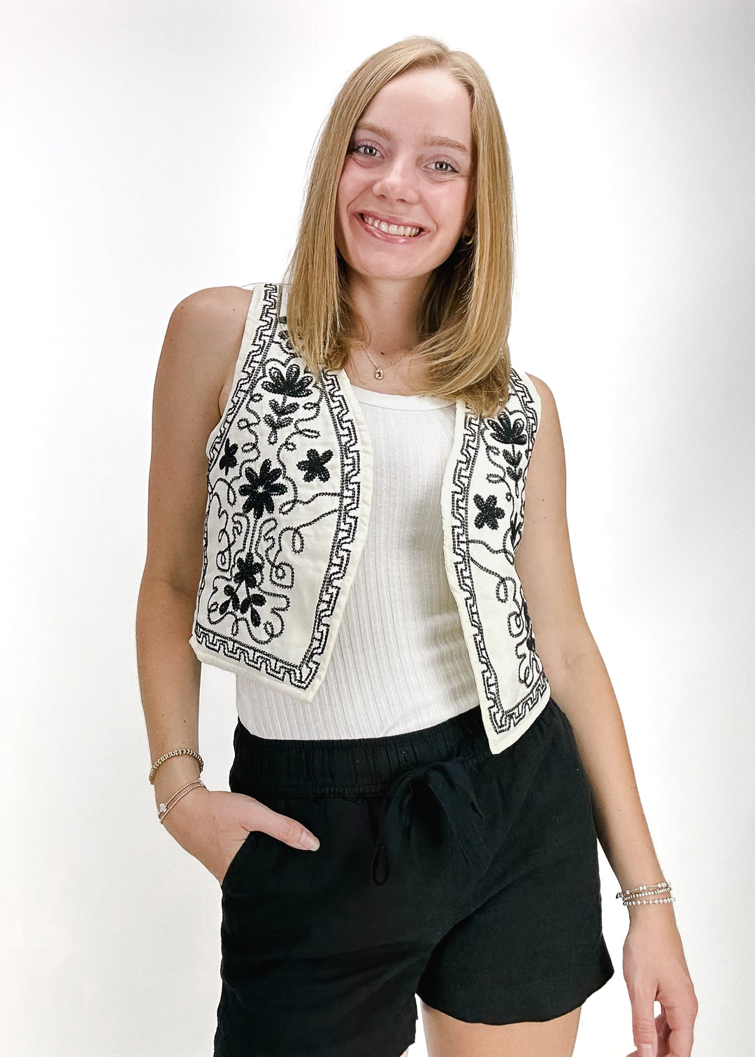 cream cropped vest with black embroidery and curved front panels