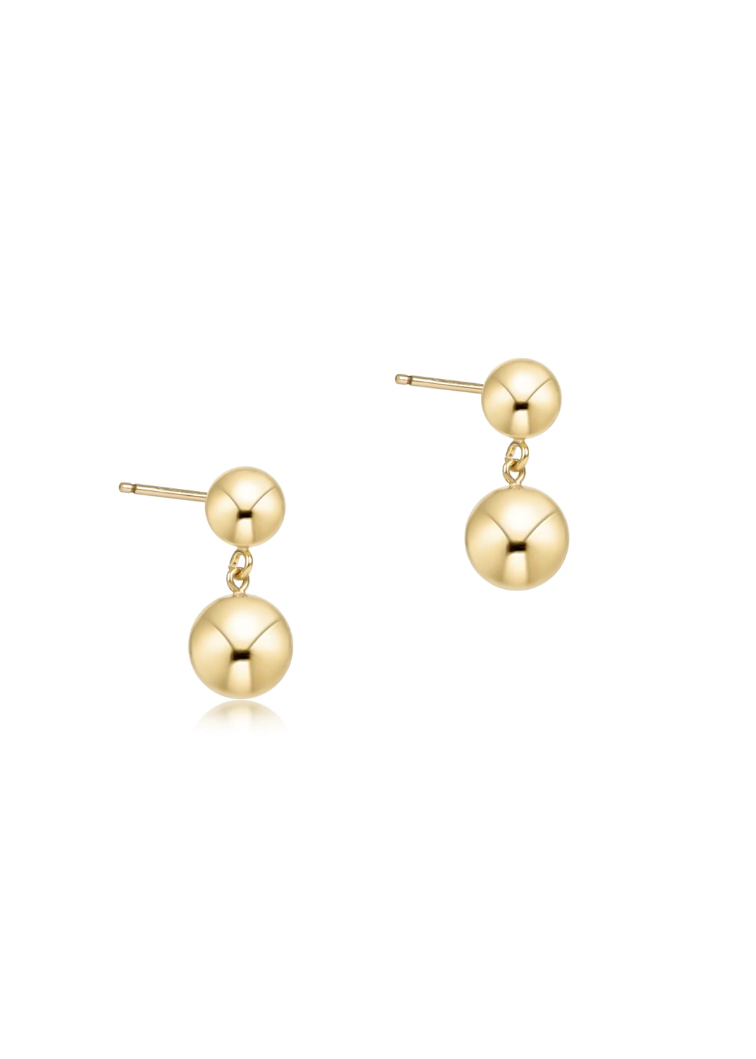 Gold earrings with two balls on a white background