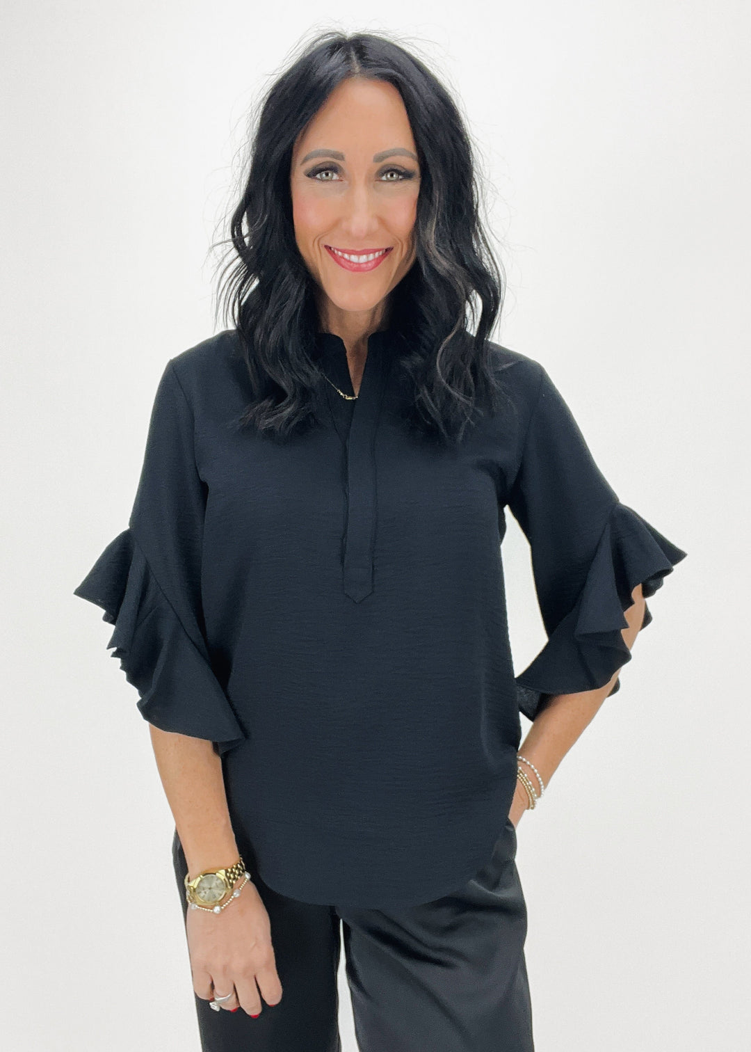 woman wearing black split neck crepe ruffle sleeve blouse with black pants