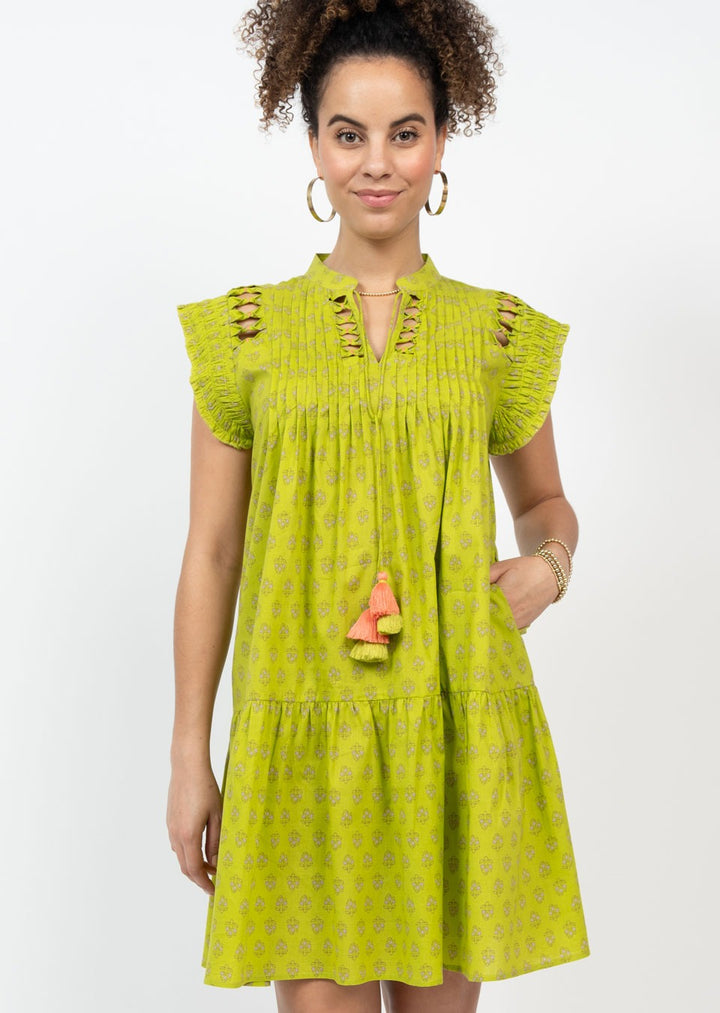 green patterned mini dress with ruffle hem, ruffle shoulders, split neck, and cut out details