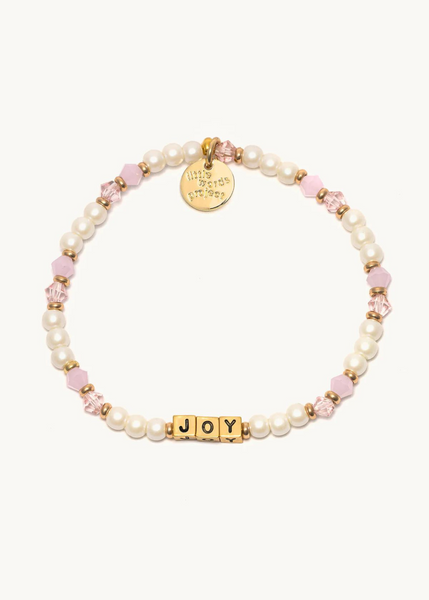 bead bracelet with pink beads and pears with "joy" written in gold cube beads