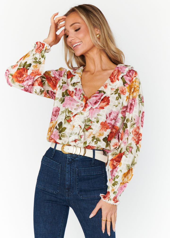 ivory, pink, rust, yellow, and green floral print v neck blouse with ruffle collar and puff sleeves