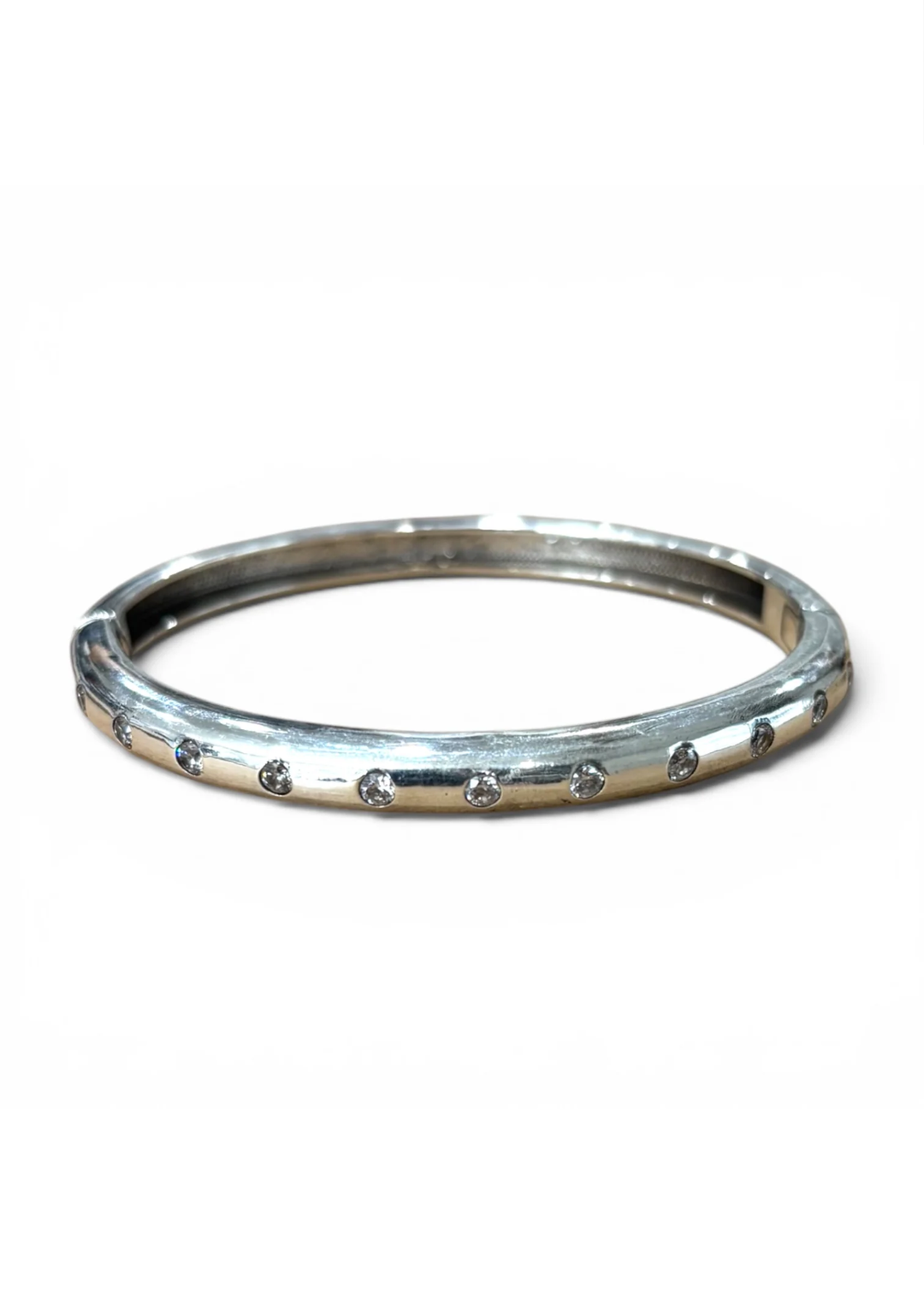 A polished silver-toned bangle bracelet with a row of small clear stones set along the front edge, shown against a plain white background.