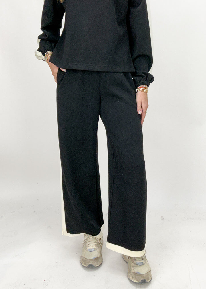 Person wearing black pants and a black top on a white background