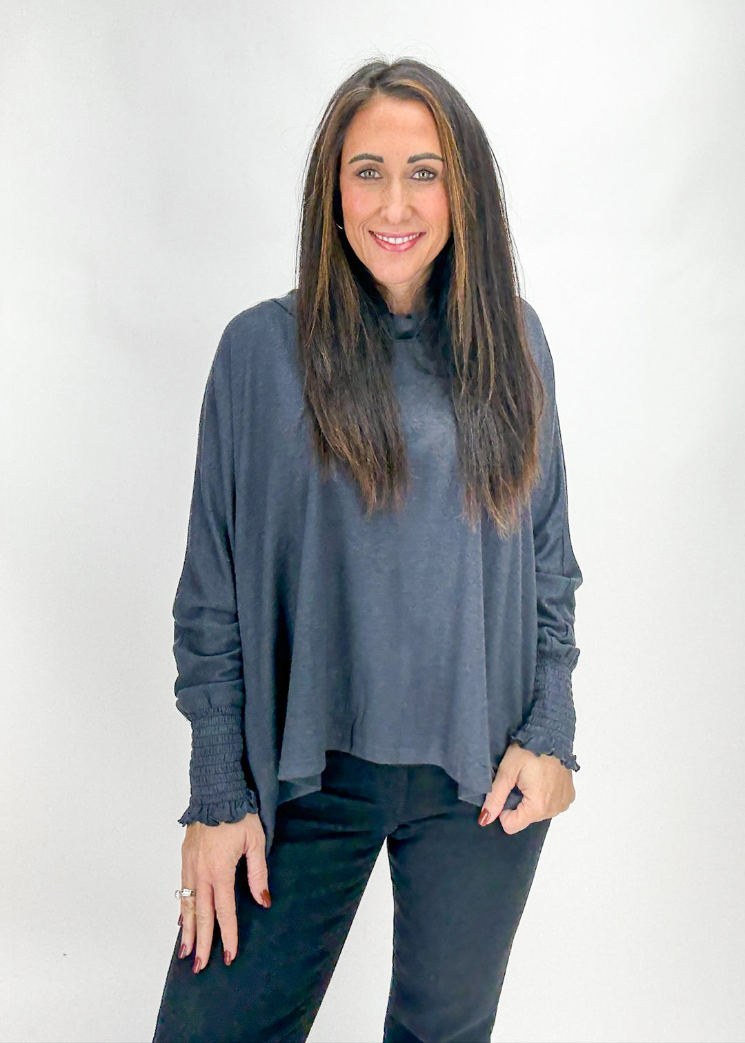 Woman wearing a gray long-sleeve top and black pants 