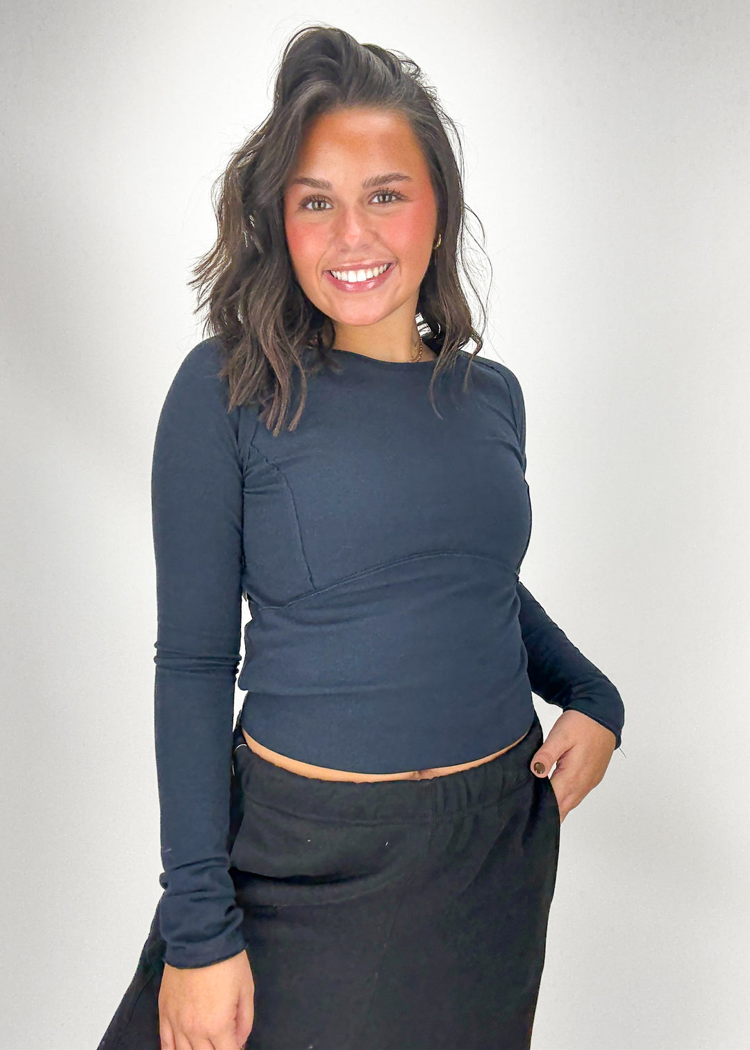 Woman wearing a navy long-sleeve top and black pants