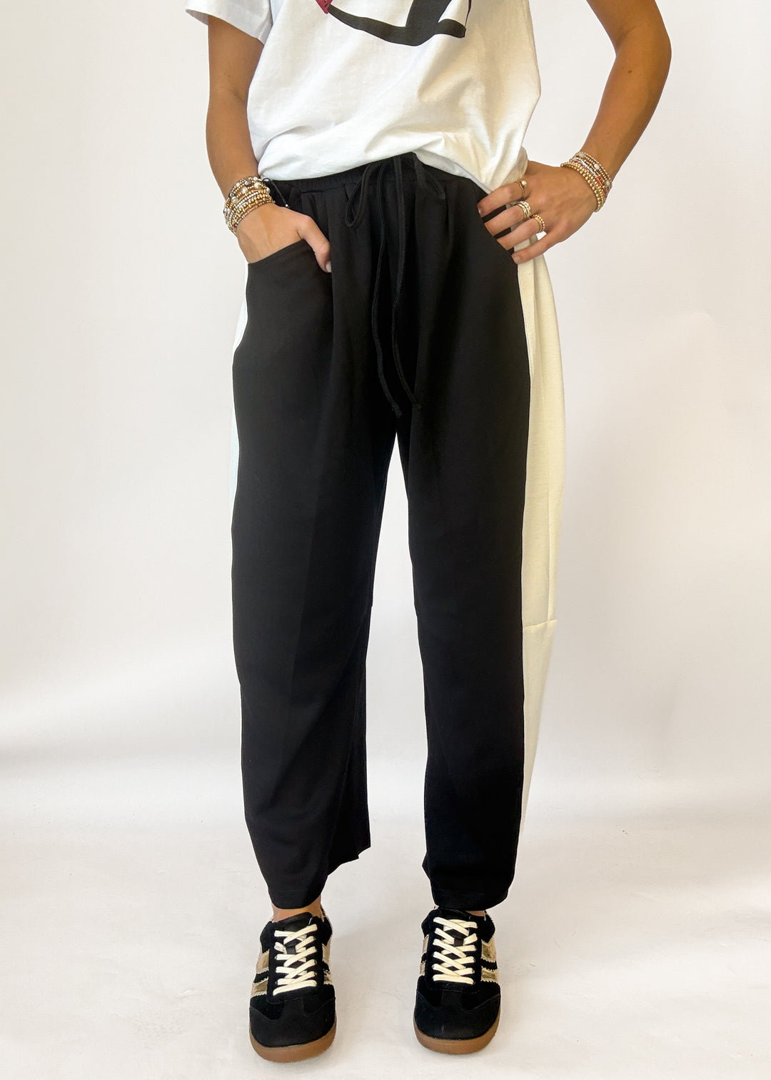 Woman wearing black barrel pants with white stripe on the side