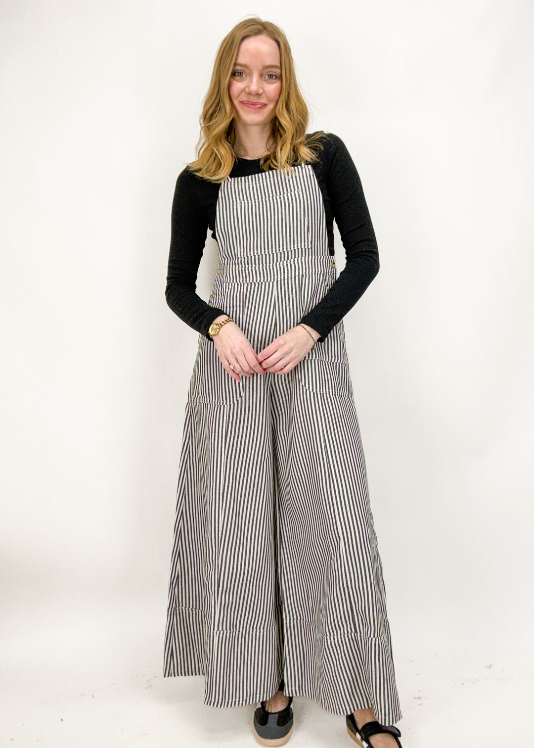 Woman wearing a black and white striped dress against a white background