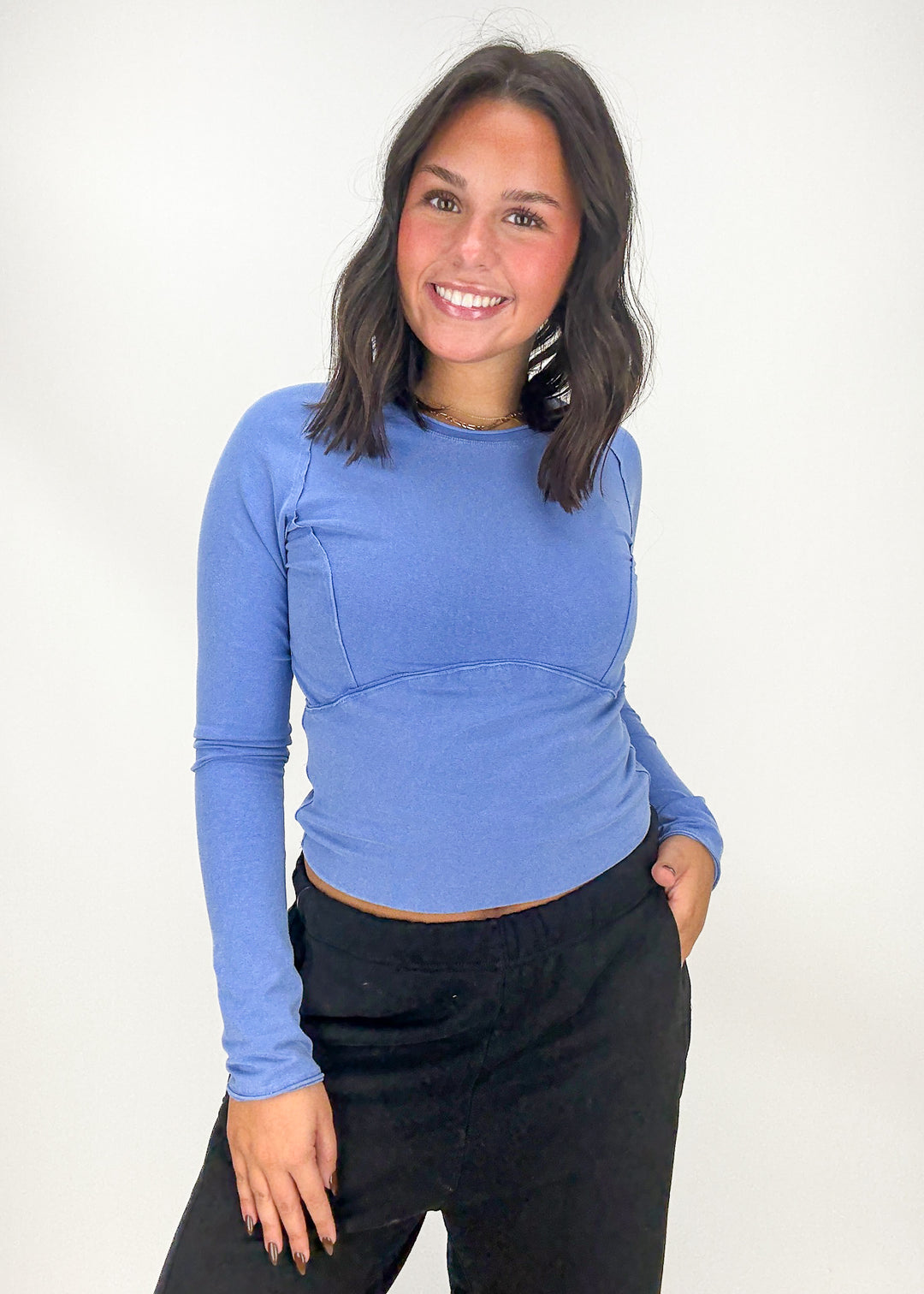 Woman wearing a blue long-sleeve top and black pants 