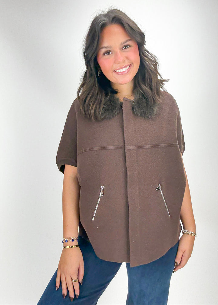 Woman wearing a brown vest with fur trim 