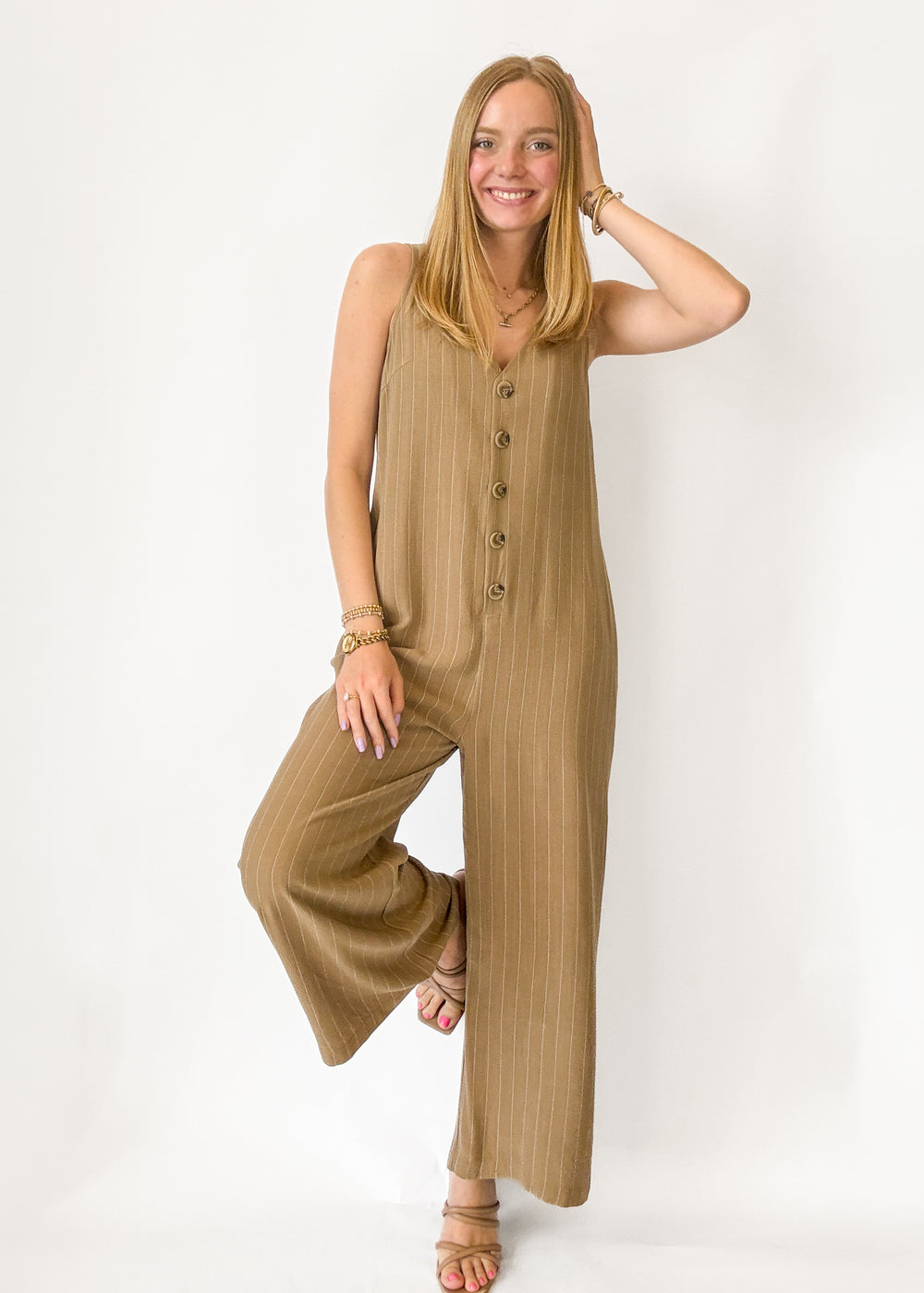 Woman wearing a beige jumpsuit on a white background