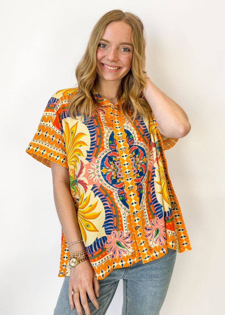 Woman wearing a colorful patterned shirt against a white background