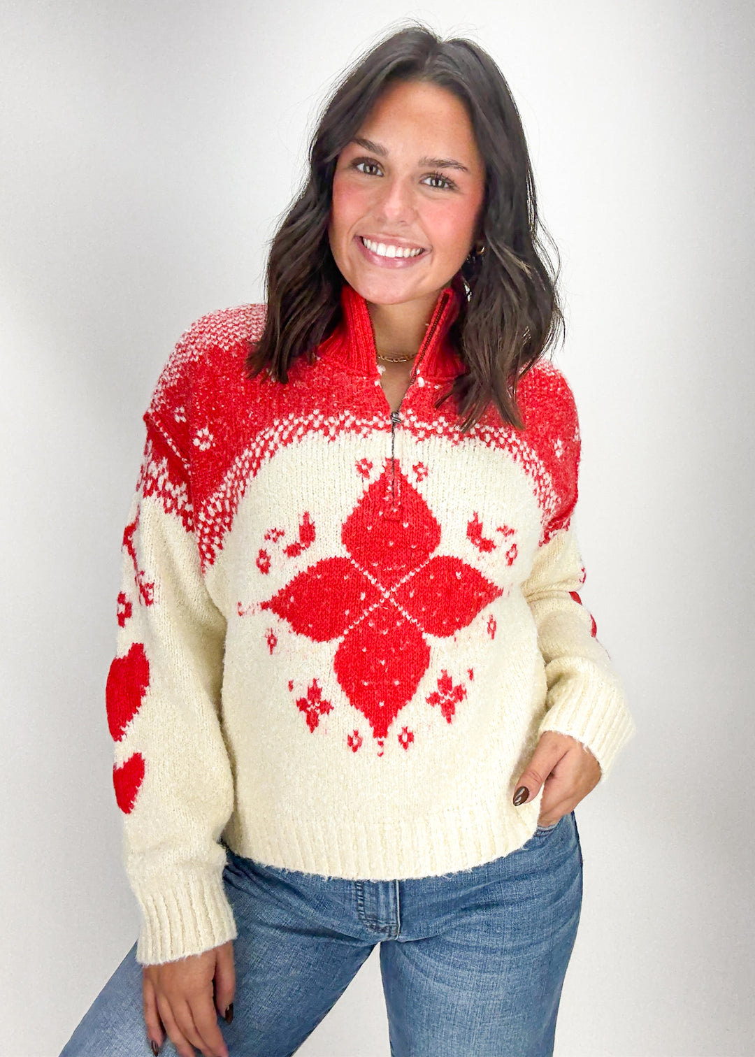 Woman wearing a red and cream patterned sweater 