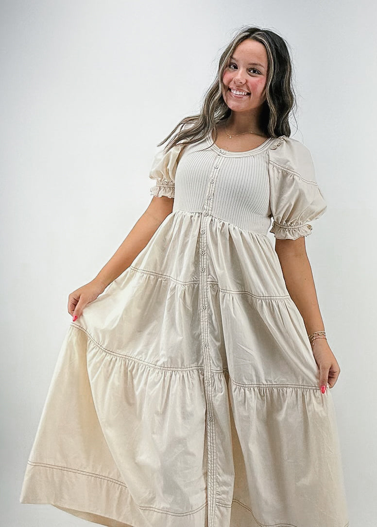 cream maxi dress with ribbed chest, puff sleeves, tiered skirt, and buttons down front