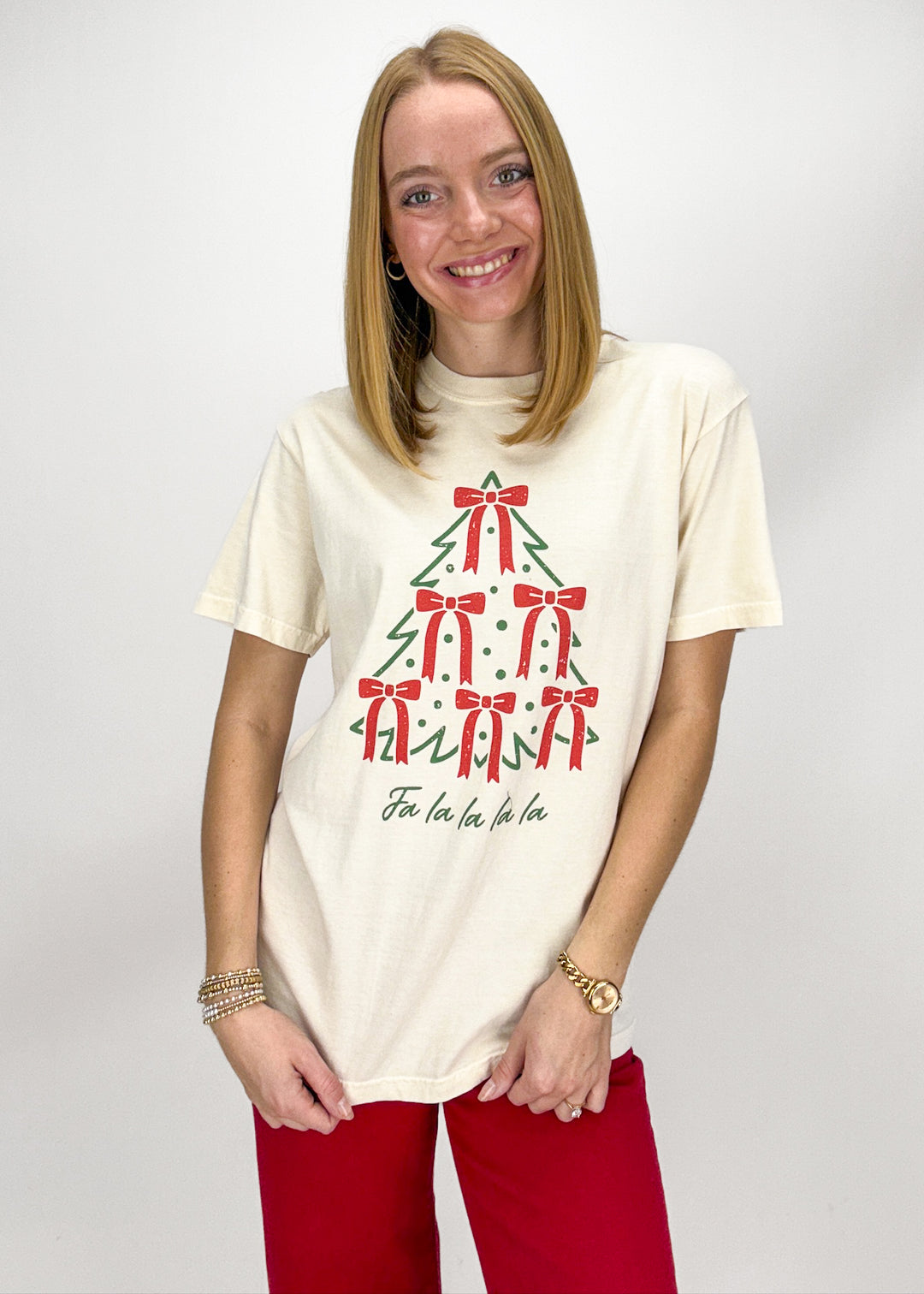 Woman wearing a cream t-shirt with a Christmas tree design 