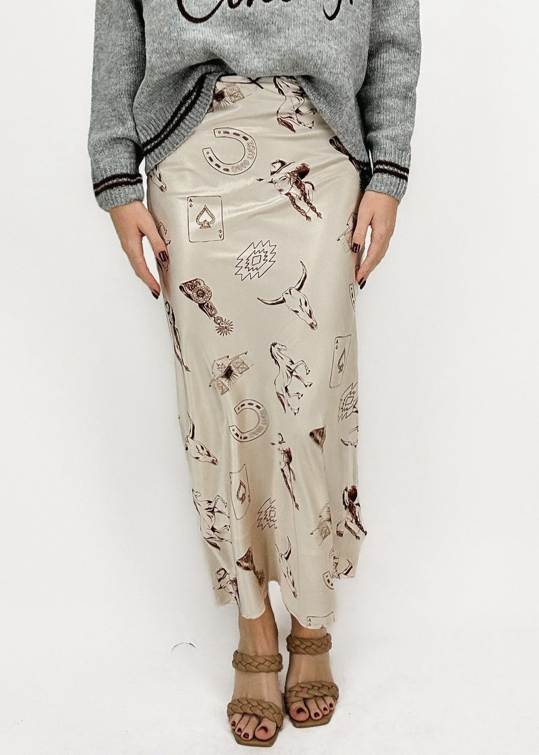 cream and brown western inspired printed midi skirt paired with "See you cowboy" graphic sweater and tan braided two-strap heels