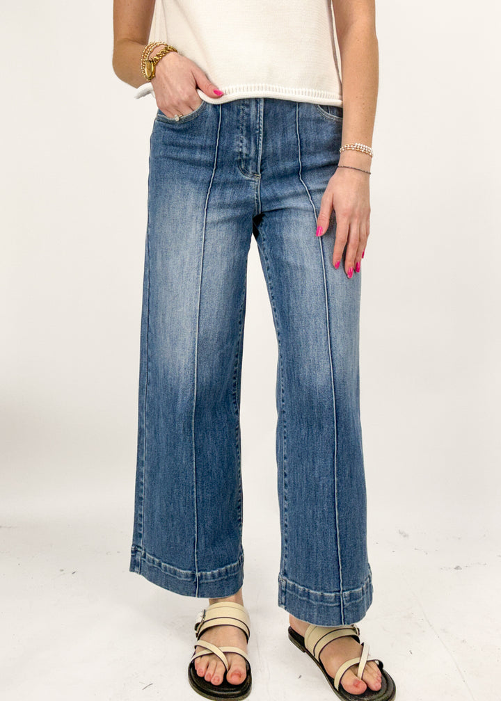 Person wearing blue jeans on a white background