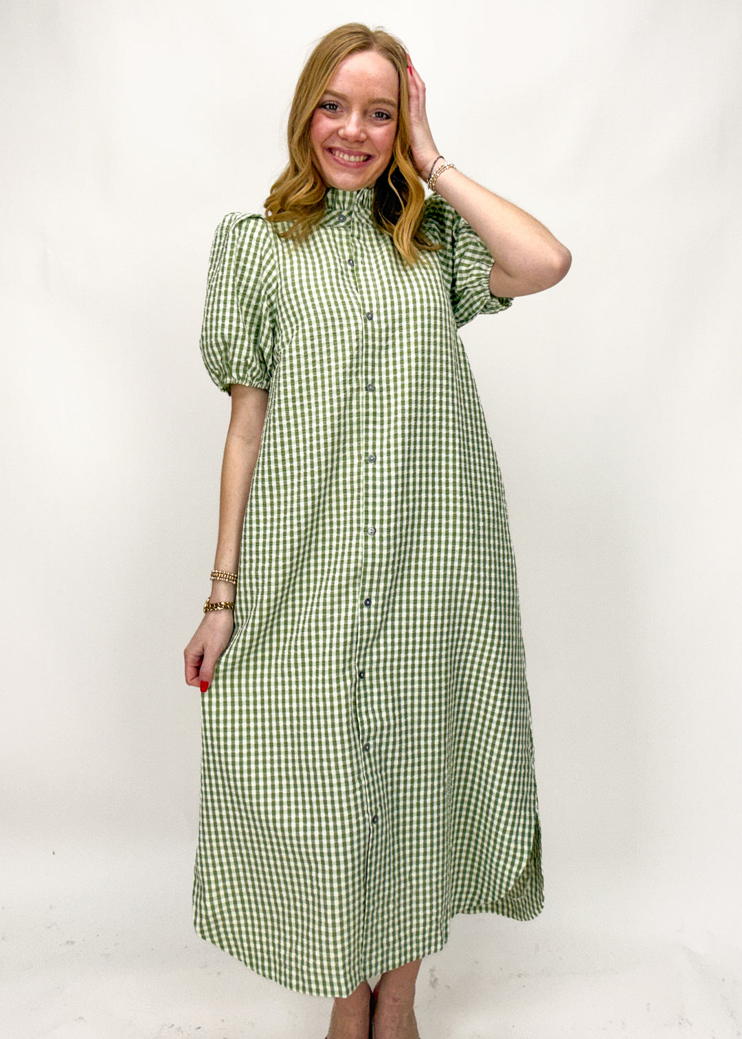 Woman wearing a green checkered dress against a white background