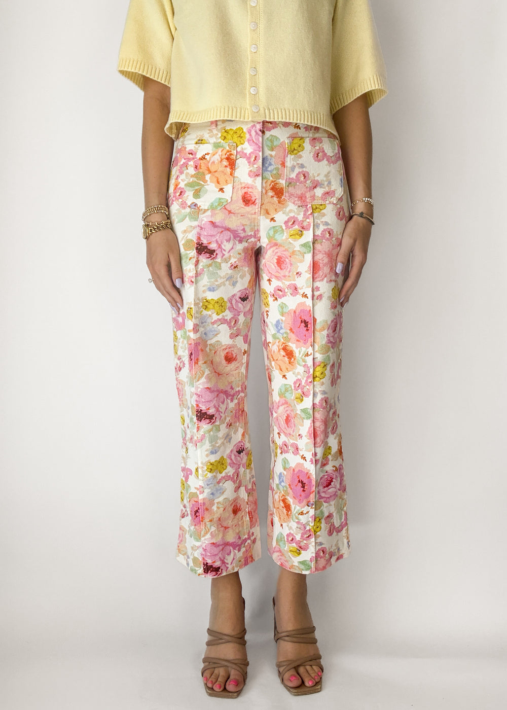 Person wearing floral pants with a plain background