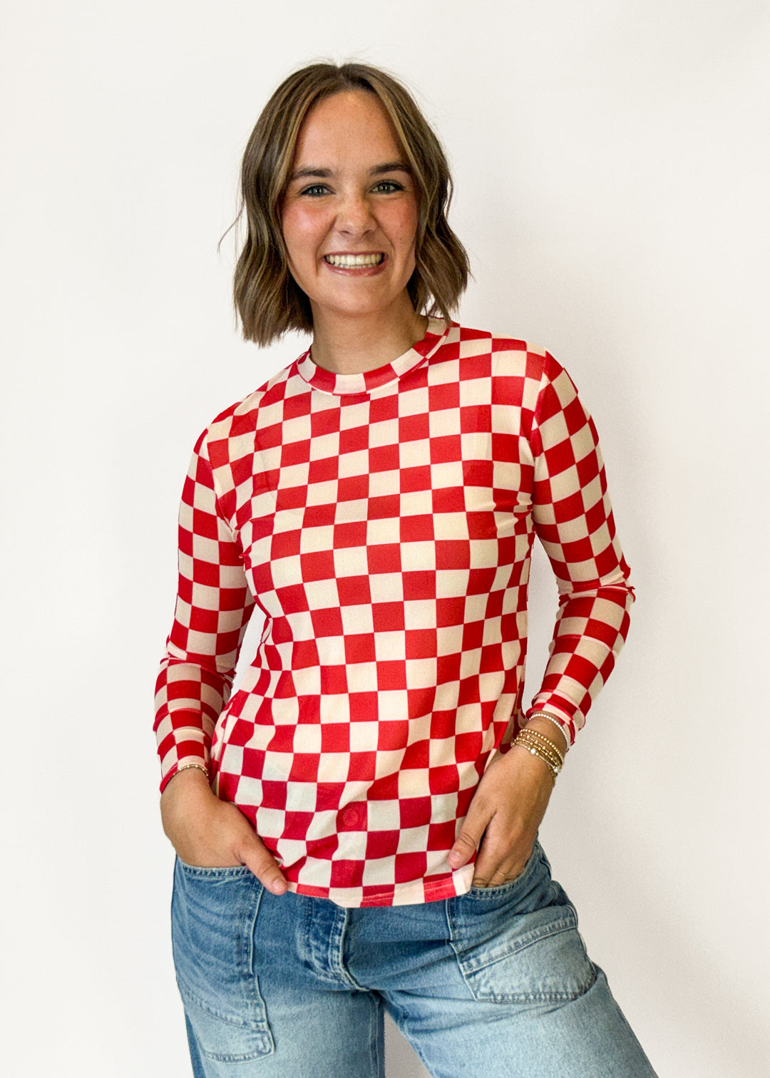 A woman wearing a red and white checkered long-sleeve top 