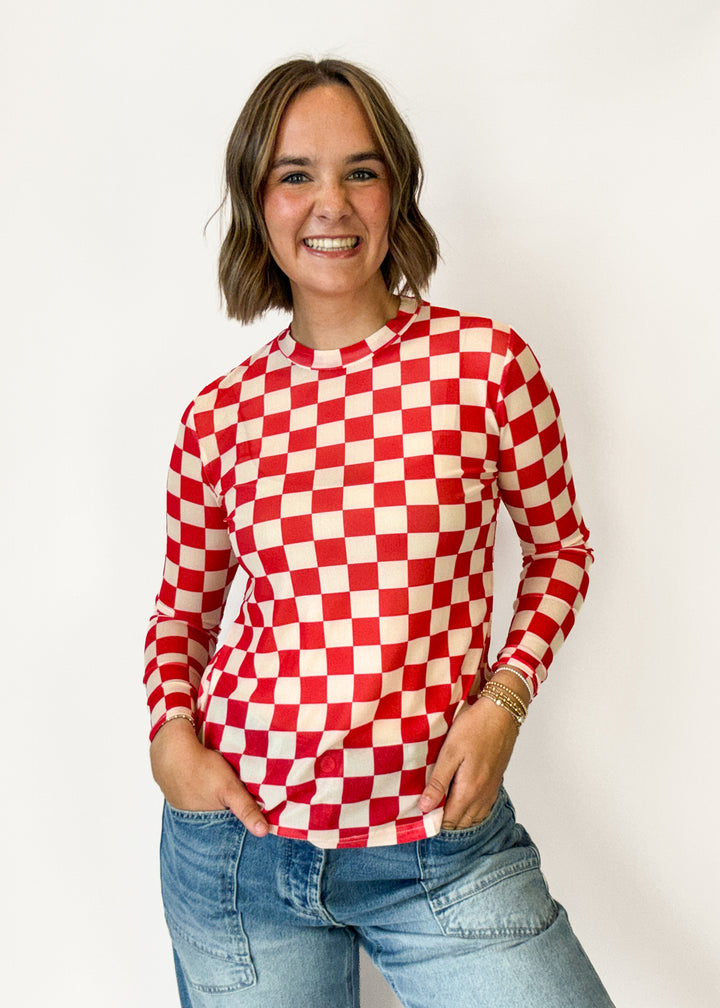 A woman wearing a red and white checkered long-sleeve top 
