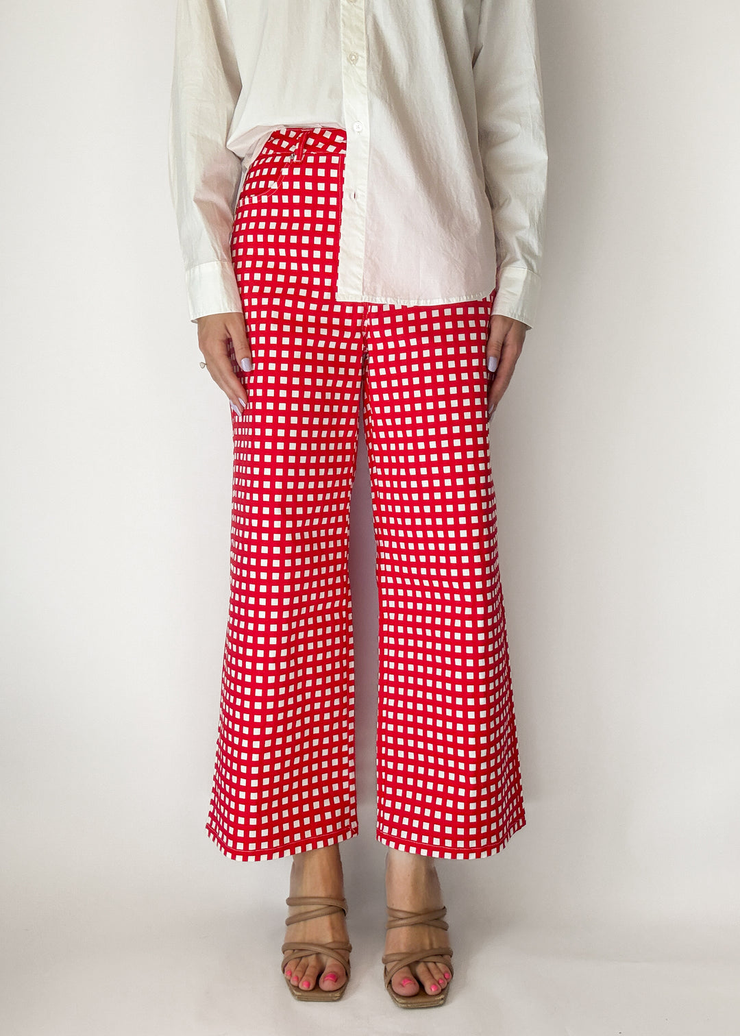 Person wearing red and white checkered pants on a plain background