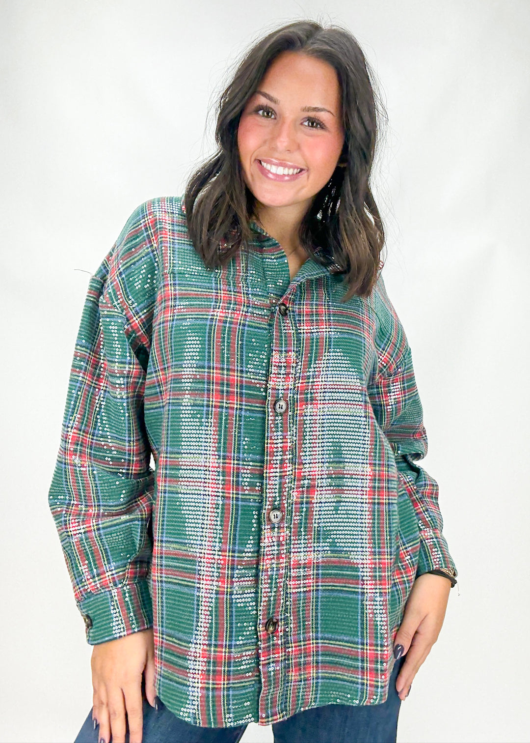 Woman wearing a green plaid shirt against a white background