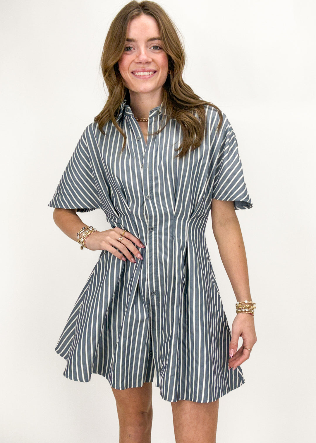 Woman wearing a striped shirt dress on a white background