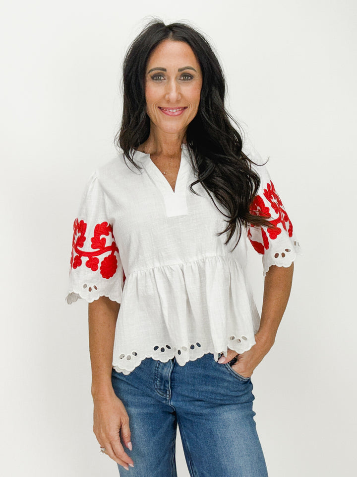 white split neck half sleeve top with red floral patchwork details and eyelet scallop trim