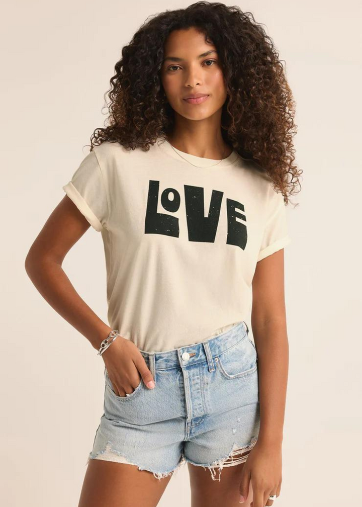 cream tan short sleeve top with black abstract block letters that read "love"