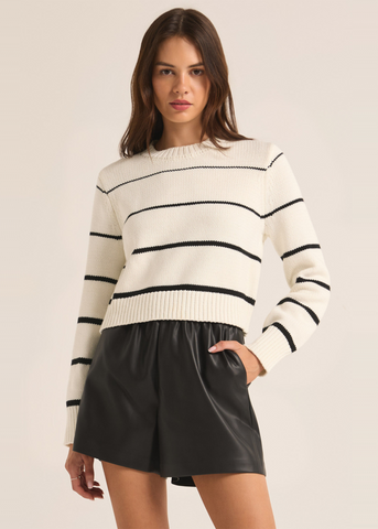 natural off white knit sweater with black stripes increasing in thickness from top to bottom 